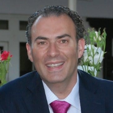 Lächelnder Mann in Anzug, der die Vorteile von Glasfaserinternet für "Unsere Grüne Glasfaser" präsentiert.