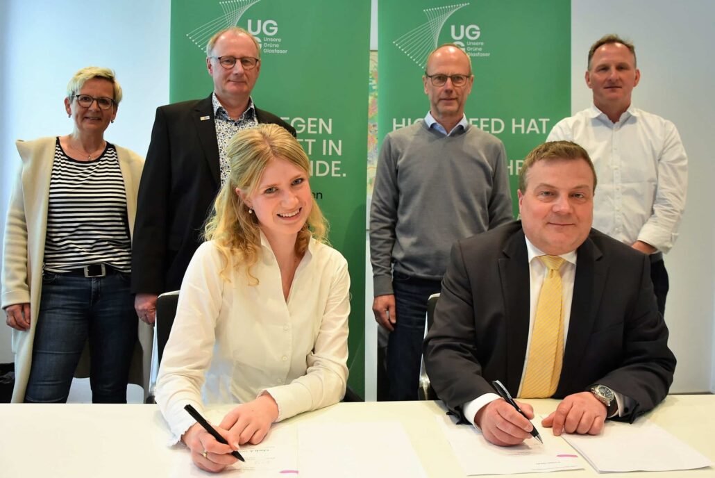 Vertragsunterzeichnung für den Ausbau von Glasfaserinfrastruktur durch Unsere Grüne Glasfaser in einer modernen Umgebung.