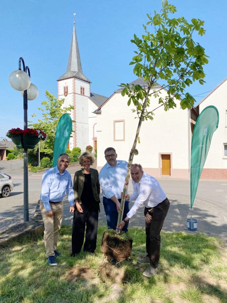 Vertreter von Unsere Grüne Glasfaser pflanzen einen Baum zur Förderung von Nachhaltigkeit und regionaler Entwicklung.