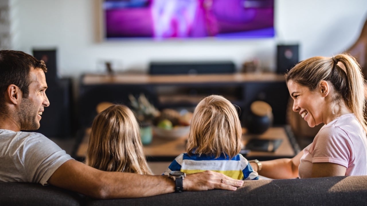 Familie genießt gemeinsamen Fernsehabend, unterstützt durch schnelle Internetverbindung von Unsere Grüne Glasfaser.