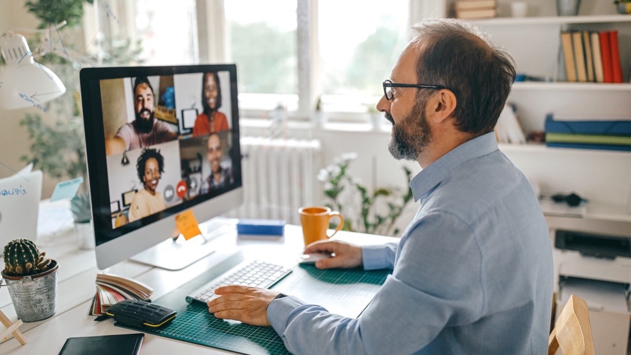 Mann im Homeoffice führt Videokonferenz, ideal für digitale Zusammenarbeit mit Unsere Grüne Glasfaser.