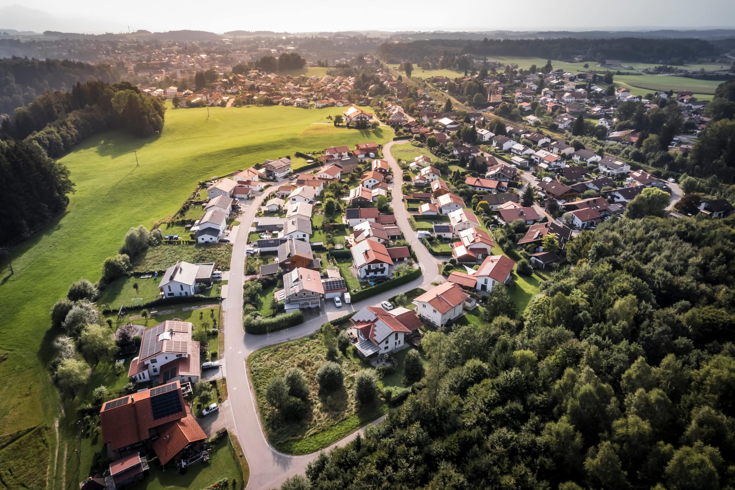 Luftaufnahme eines Wohngebiets mit Einfamilienhäusern und grünen Flächen, ideal für den Ausbau von Glasfaseranschlüssen.