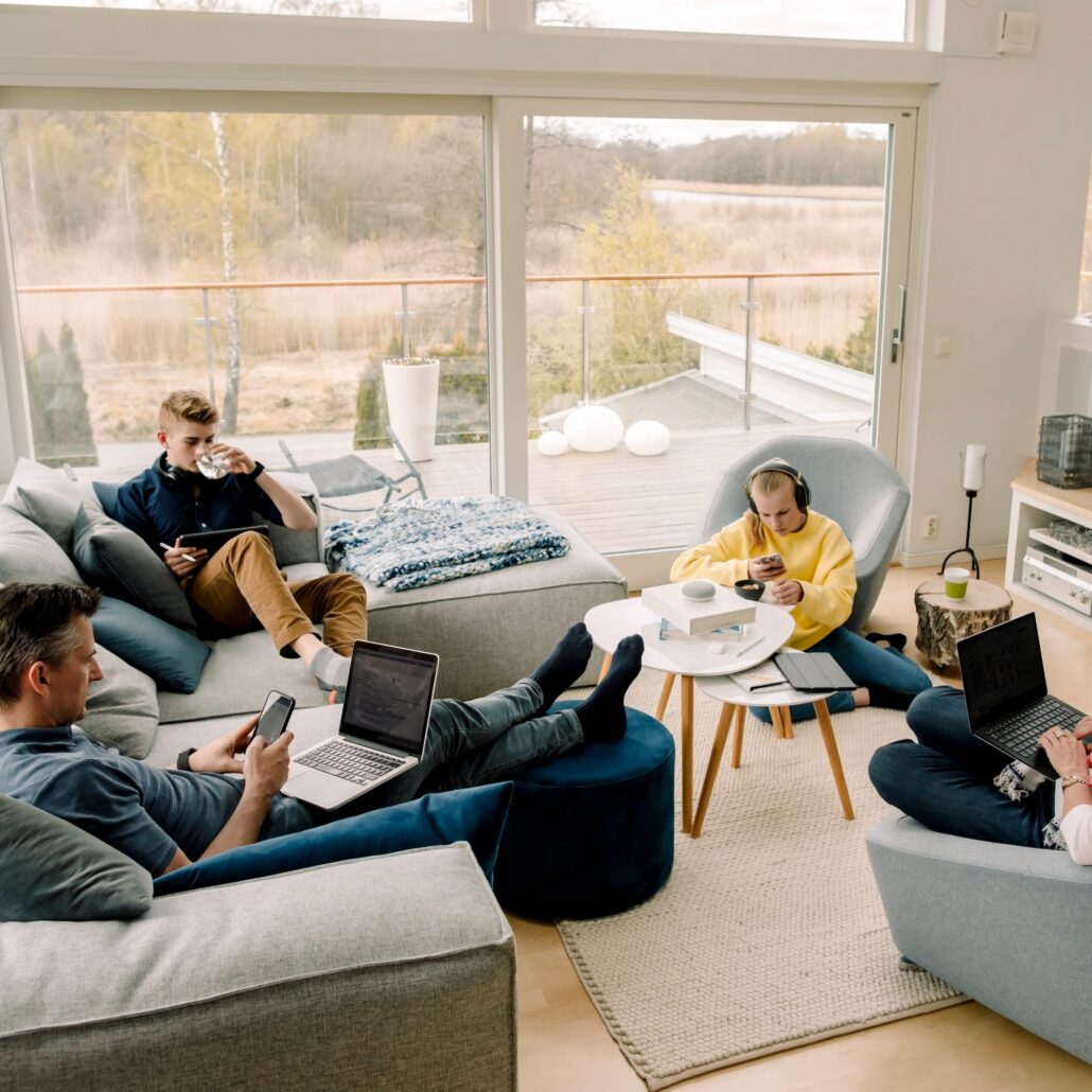 Familie nutzt modernes Homeoffice mit Glasfaser-Internet für Arbeit und Freizeit in einem hellen Wohnraum.