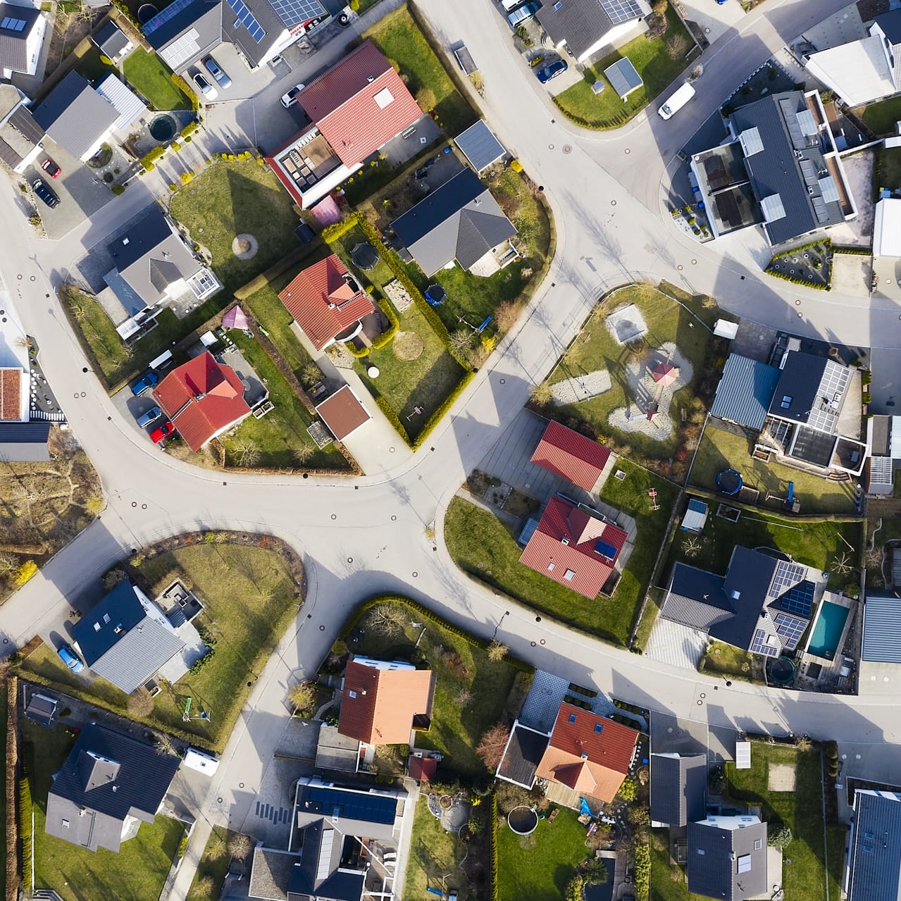 Luftaufnahme eines Wohngebiets mit Einfamilienhäusern und Gärten, ideal für schnelle Internetanbindungen von Unsere Grüne Glasfaser.