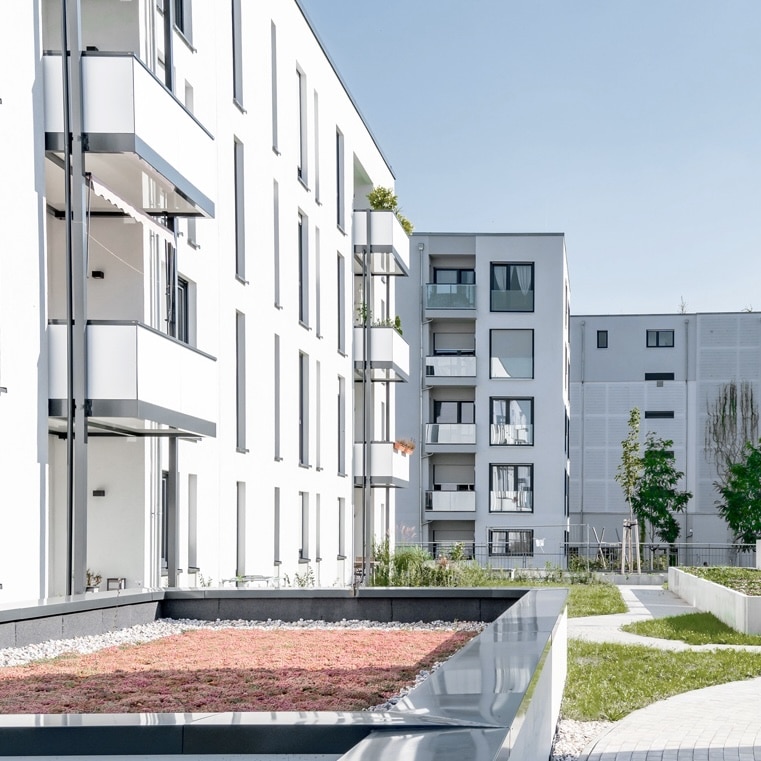 Moderne Wohnanlage mit begrünten Außenbereichen, ideal für schnelles Internet von Unsere Grüne Glasfaser.