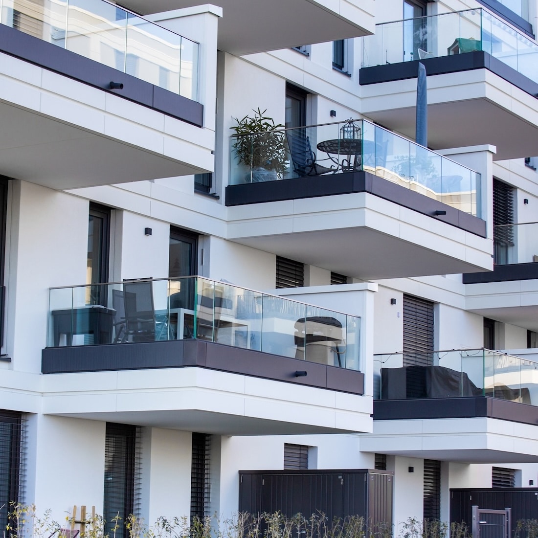 Moderne Wohnanlage mit Balkonen und Glasgeländern, ideal für schnelle Internetverbindungen von Unsere Grüne Glasfaser.