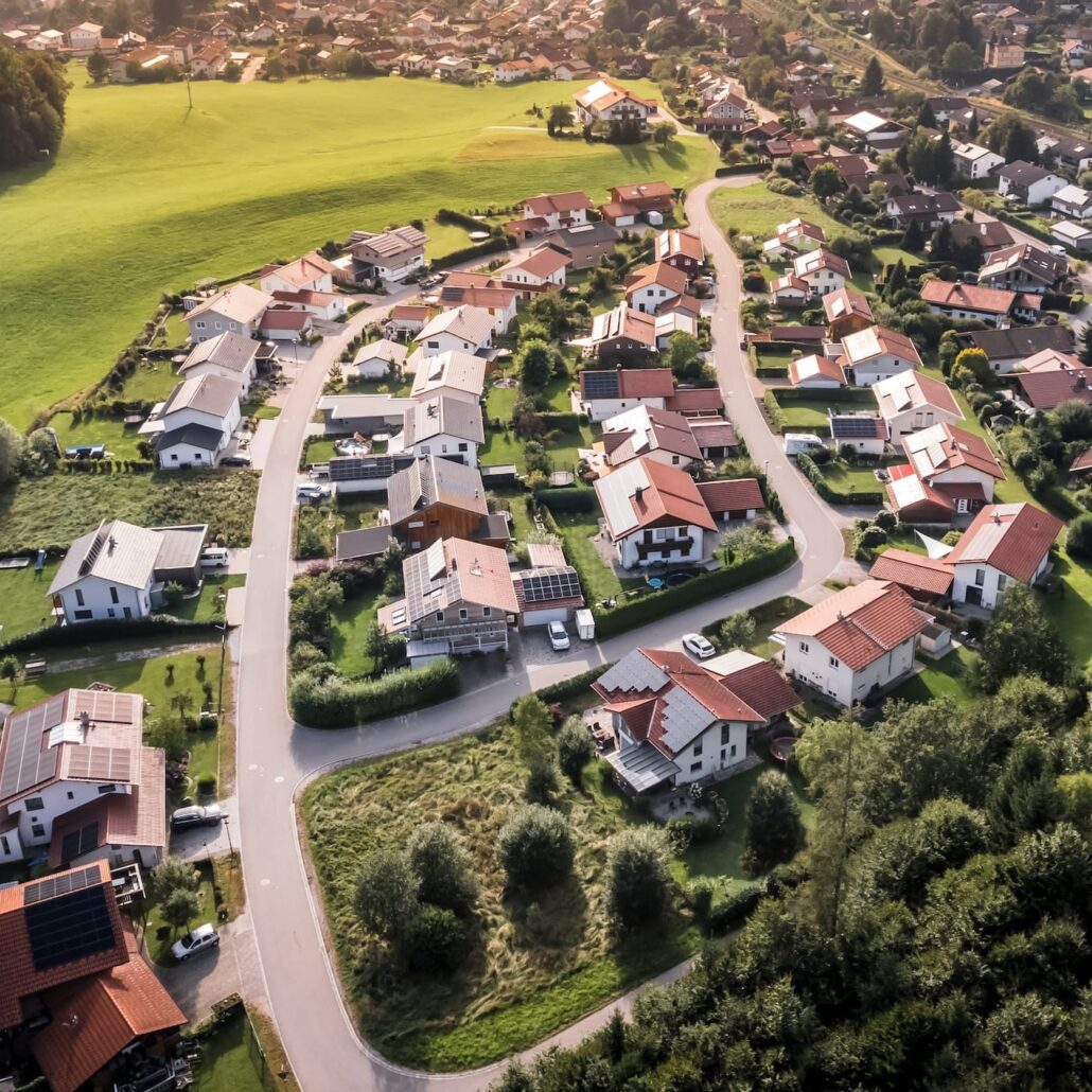 Luftaufnahme eines Wohngebiets mit Einfamilienhäusern und grünen Flächen, ideal für Glasfaseranbindungen von Unsere Grüne Glasfaser.
